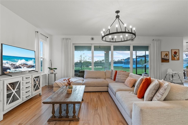 living room with light hardwood / wood-style floors, an inviting chandelier, and plenty of natural light