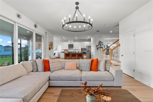 living room with sink, light hardwood / wood-style flooring, and a chandelier