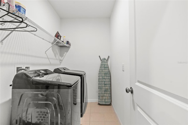 clothes washing area featuring washer and dryer and light tile patterned floors