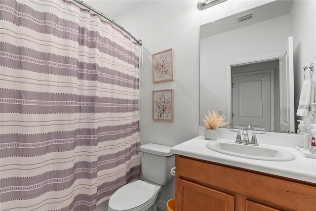 bathroom with vanity, toilet, curtained shower, and visible vents