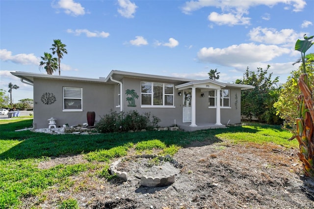 view of front of home with stucco siding, a porch, and a front yard