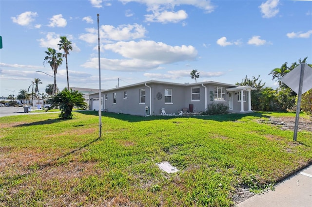 view of front facade featuring stucco siding, a garage, and a front lawn