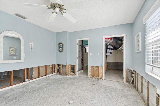 spare room featuring visible vents, a textured ceiling, and a ceiling fan