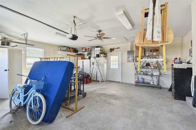 garage featuring electric panel, ceiling fan, and a garage door opener