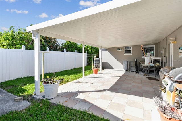 view of patio / terrace featuring an attached carport and fence