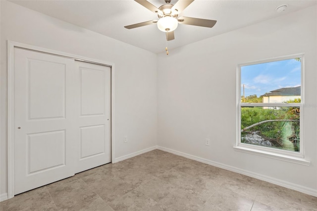 unfurnished bedroom featuring a closet, multiple windows, and ceiling fan