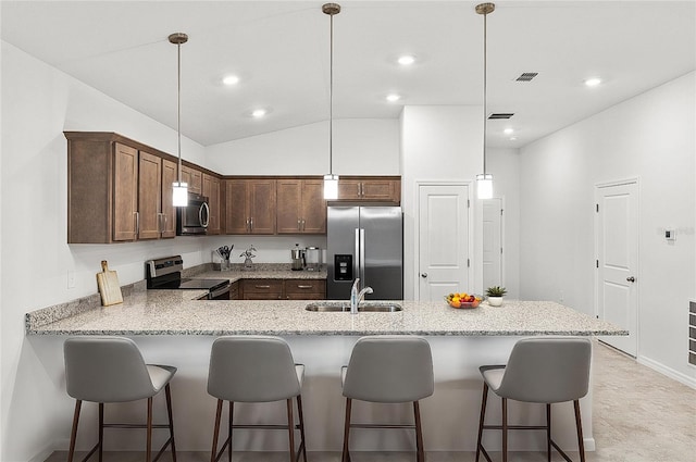 kitchen with kitchen peninsula, stainless steel appliances, sink, pendant lighting, and lofted ceiling