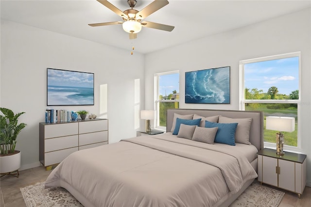 bedroom with multiple windows, ceiling fan, and light hardwood / wood-style flooring