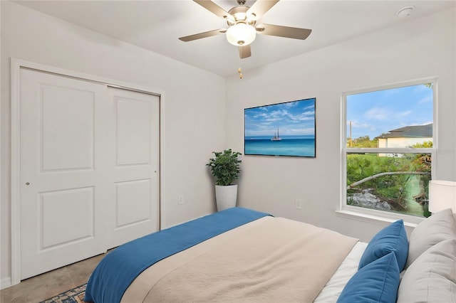 tiled bedroom with ceiling fan and a closet