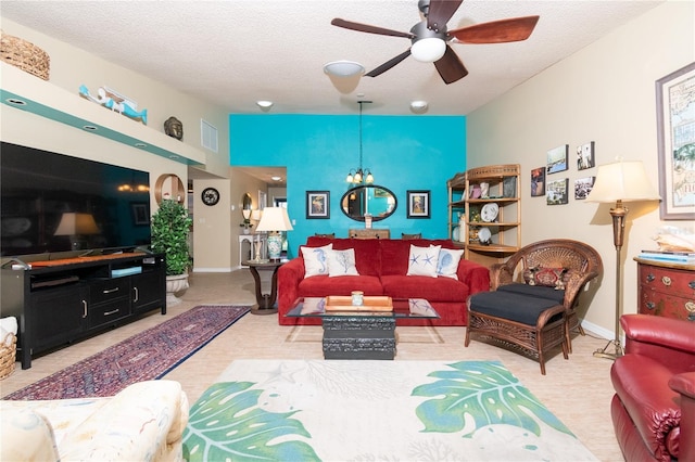 living room featuring ceiling fan with notable chandelier and a textured ceiling