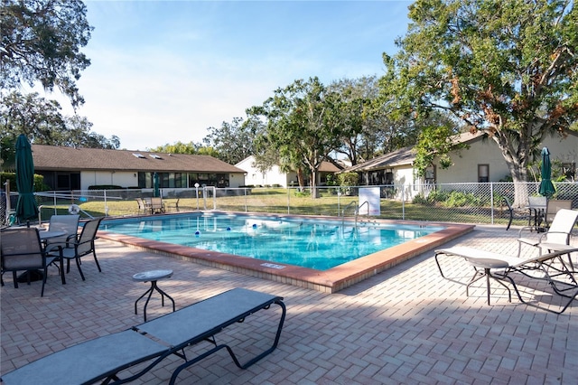 pool with a patio and fence