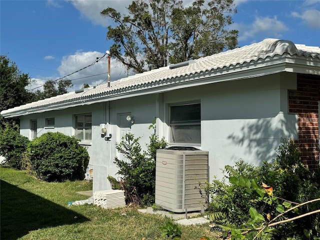 view of home's exterior featuring a yard and central AC unit