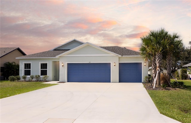 view of front facade featuring a garage and a yard