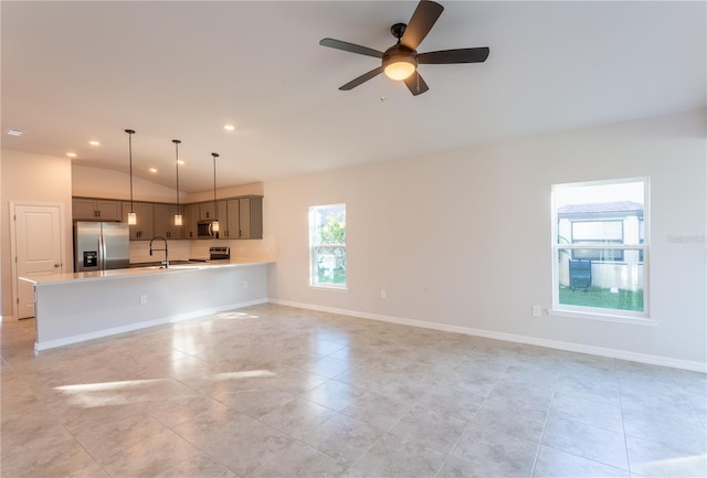 unfurnished living room with light tile patterned flooring, vaulted ceiling, ceiling fan, and sink