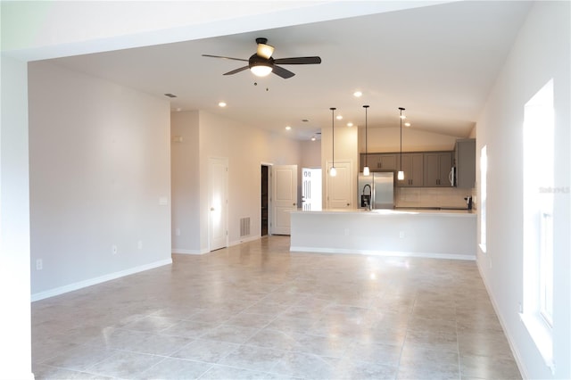 unfurnished living room with ceiling fan, sink, light tile patterned floors, and lofted ceiling