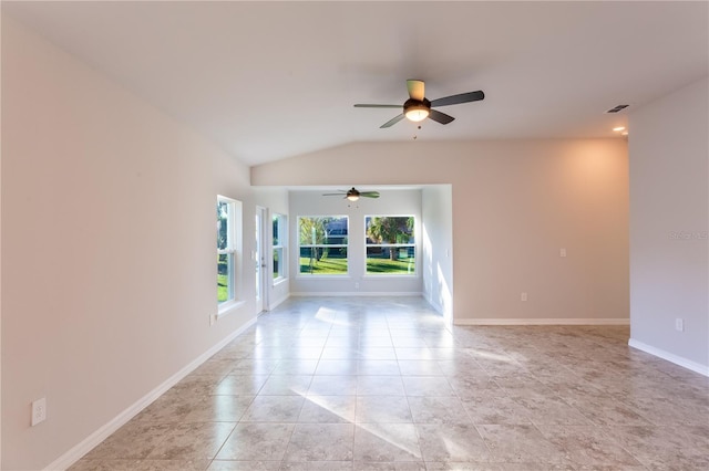 empty room with ceiling fan, lofted ceiling, and light tile patterned flooring