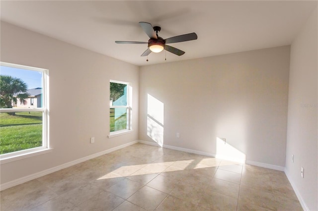 tiled spare room featuring ceiling fan and a healthy amount of sunlight