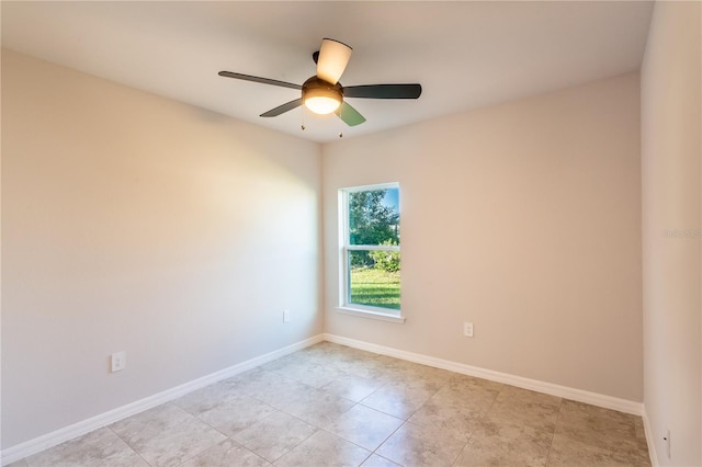 empty room with ceiling fan and light tile patterned floors