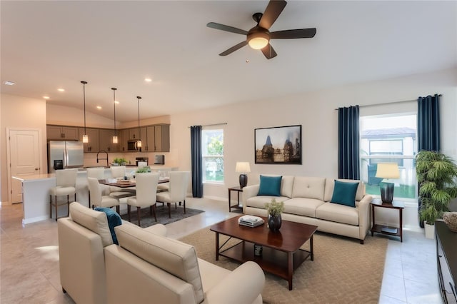 tiled living room with ceiling fan, lofted ceiling, and sink