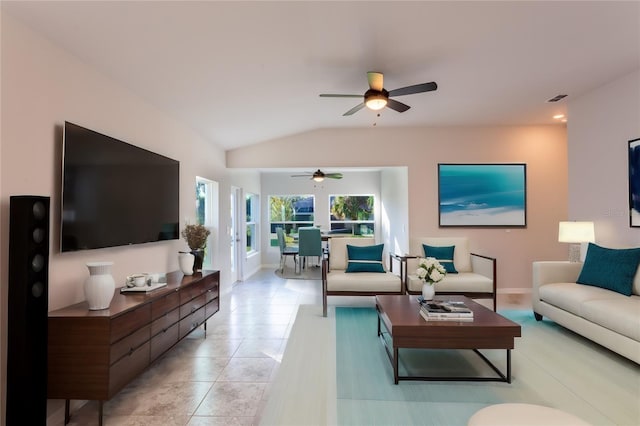 living room featuring ceiling fan, lofted ceiling, and light tile patterned floors