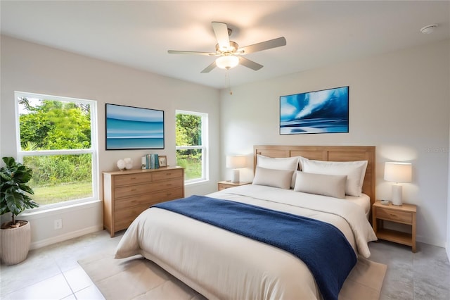 tiled bedroom with ceiling fan and multiple windows