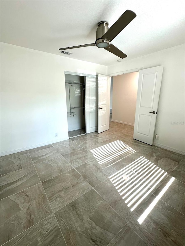 unfurnished bedroom featuring ceiling fan and a closet