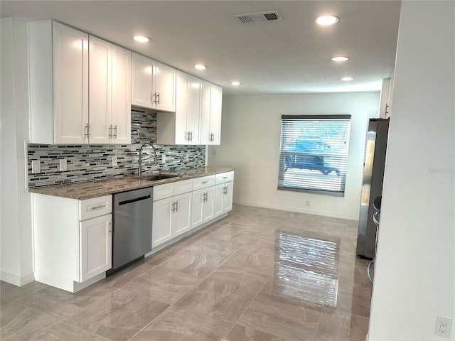 kitchen featuring stainless steel appliances, a sink, visible vents, and white cabinetry