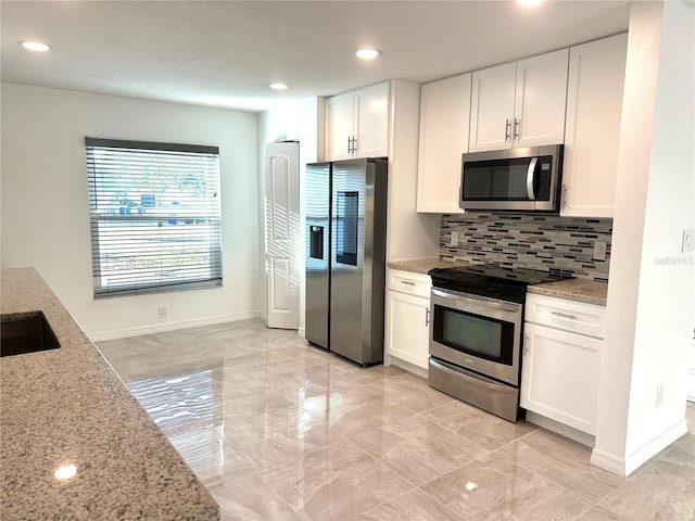 kitchen with tasteful backsplash, light stone countertops, stainless steel appliances, white cabinetry, and recessed lighting