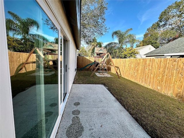 view of yard with a fenced backyard, a playground, and a patio