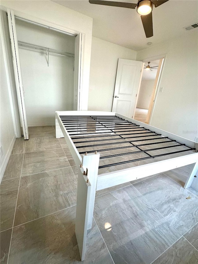 unfurnished bedroom with baseboards, a closet, visible vents, and a ceiling fan