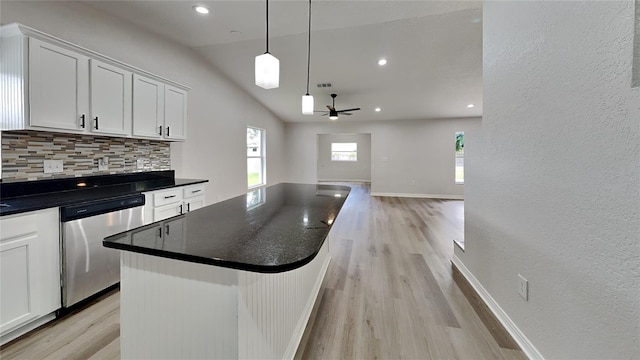 kitchen featuring ceiling fan, stainless steel dishwasher, backsplash, lofted ceiling, and white cabinets