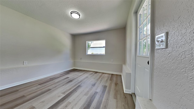 empty room featuring light hardwood / wood-style floors and a textured ceiling