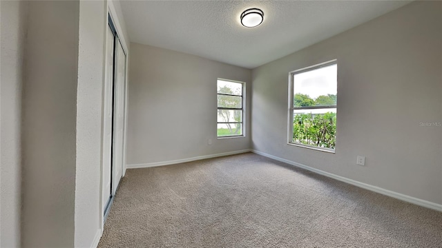 unfurnished bedroom with a closet, carpet floors, and a textured ceiling