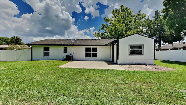 rear view of property featuring central AC unit, a yard, and a patio