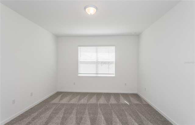 unfurnished room with carpet floors and baseboards