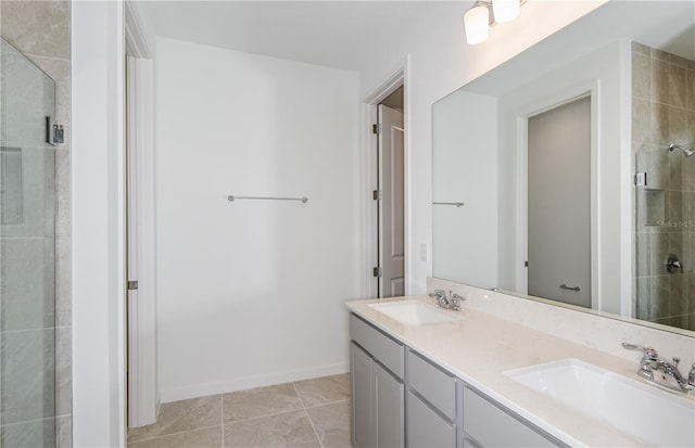 bathroom with double vanity, a stall shower, tile patterned flooring, and a sink