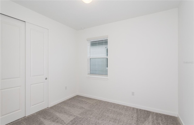 unfurnished bedroom featuring a closet, carpet flooring, and baseboards