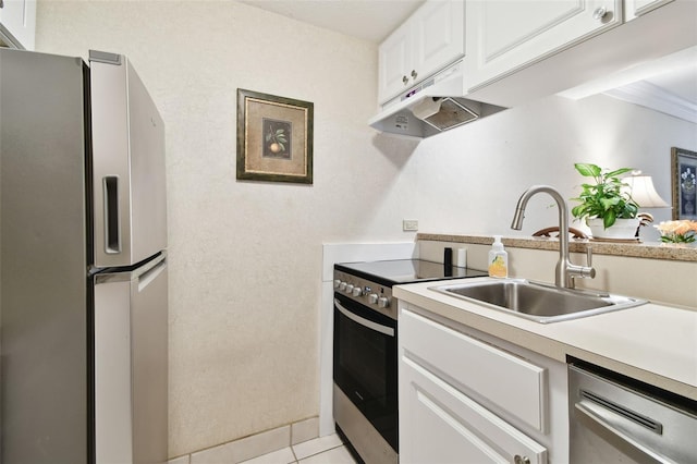 kitchen featuring white cabinets, appliances with stainless steel finishes, light tile patterned flooring, and sink