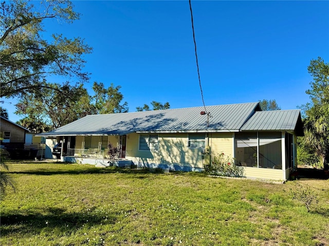 rear view of house featuring a yard