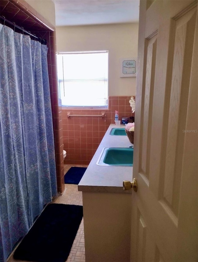 bathroom featuring vanity, toilet, and tile walls