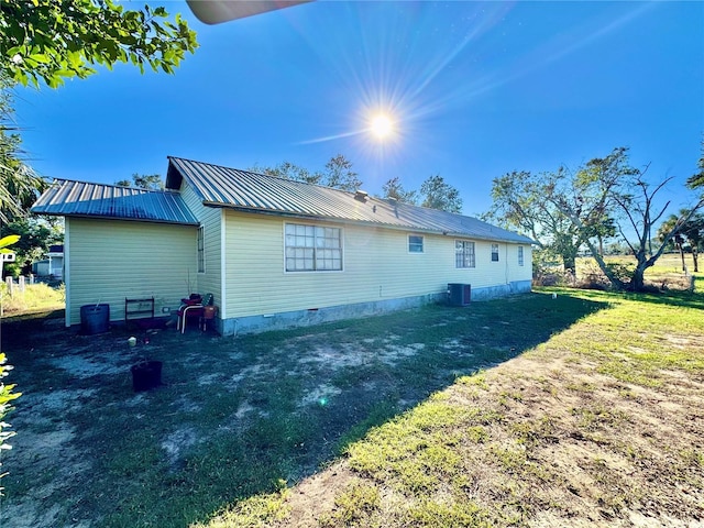 back of property featuring a yard and central AC