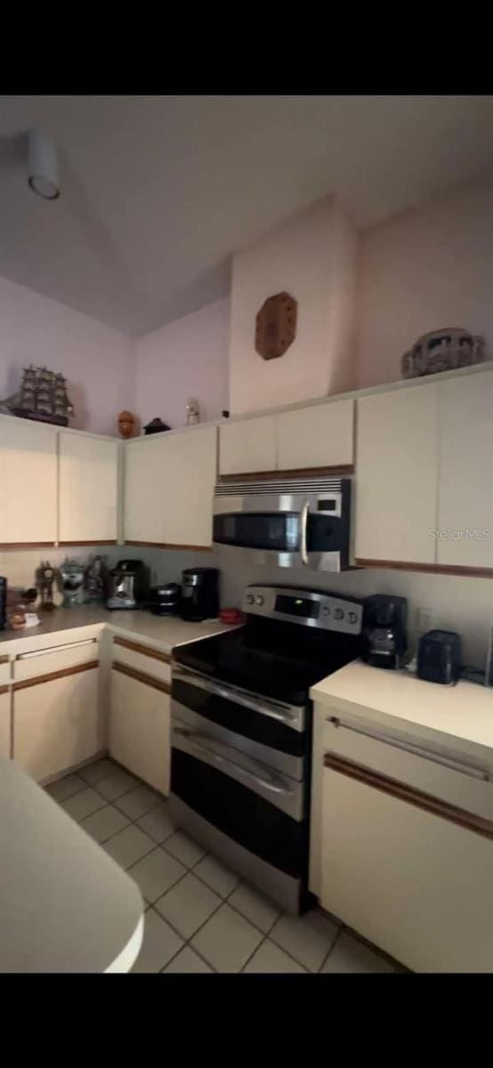 kitchen featuring light tile patterned flooring and appliances with stainless steel finishes