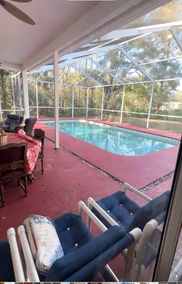 view of swimming pool featuring glass enclosure and a patio area