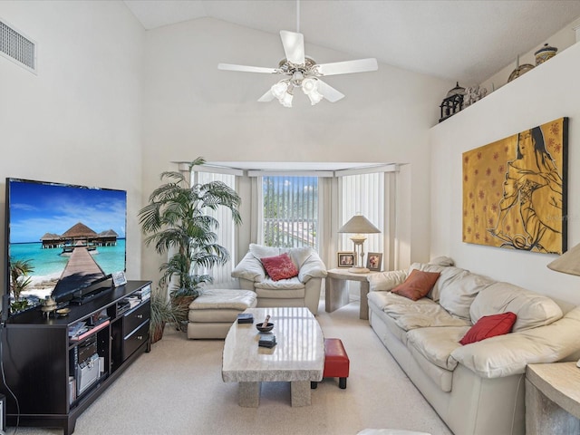 carpeted living room with ceiling fan and high vaulted ceiling