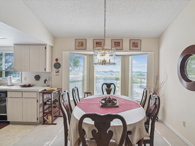 dining room with a notable chandelier, a textured ceiling, and light carpet