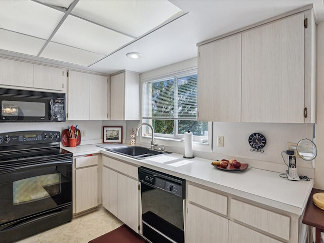 kitchen with light brown cabinetry, sink, and black appliances