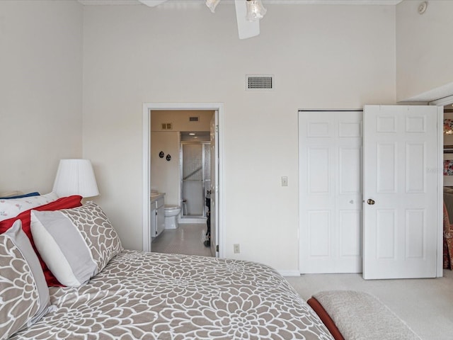 carpeted bedroom featuring a towering ceiling, a closet, and connected bathroom