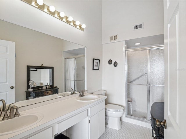 bathroom featuring tile patterned floors, vanity, a shower with shower door, and toilet