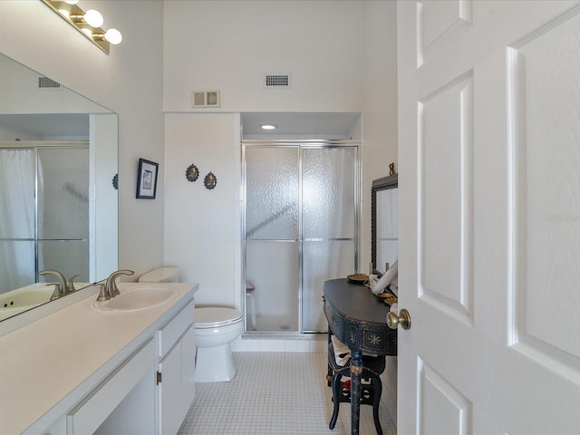 bathroom with tile patterned flooring, vanity, toilet, and a shower with door