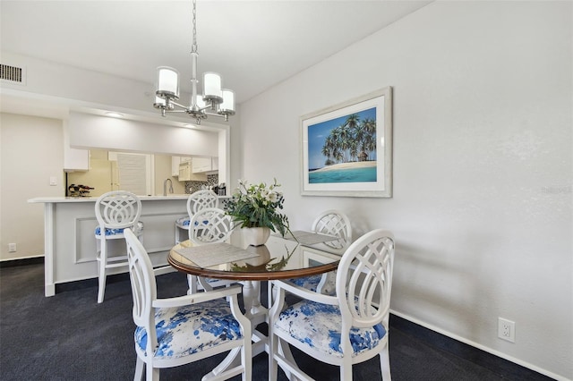 dining area with a notable chandelier, dark carpet, and sink